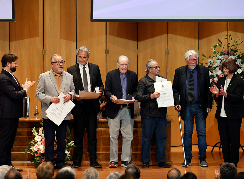 El Presidente Gabriel Boric junto a los Premios Nacionales Ramón Díaz Eterovic, Alejandro Maass, Jaime Vadell, Alejandro González y José Bengoa, además de la rectora Rosa Devés.